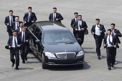 Miembros de seguridad corren junto al coche del presidente norcoreano, Kim Jong-un.