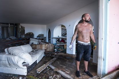 Un hombre limpia su vivienda destruida por los efectos del huracán en la bahía de Orient de la Isla de septiembre.