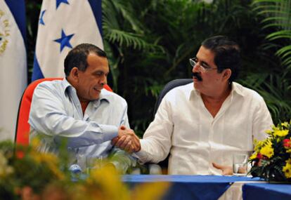 El presidente hondureño, Porfirio Lobo, estrecha manos con Manuel Zelaya en el marco de la cumbre que abrió la puerta a su regreso