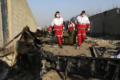 En la aeronave, un Boeing 737, viajaban 176 personas entre pasajeros y tripulantes de la aerolínea Ukraine International Airlines (UIA). En la imagen, personal de emergencias trasladan el cuerpo de una de las víctimas del accidente aéreo.