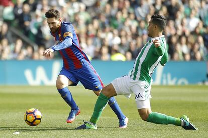 Messi (i), del Barcelona, se marcha del jugador Petros del Betis.