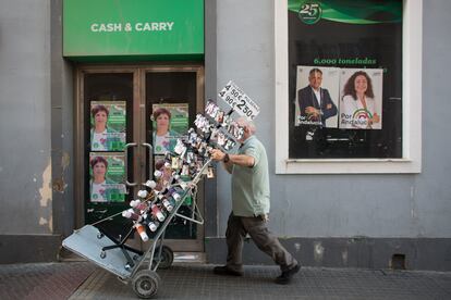 Un comerciante recoge un expositor con 'souvenirs' de una tienda del centro de Cádiz.