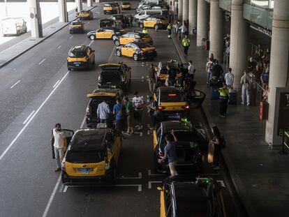 Taxistas recogen a clientes en el aeropuerto de El Prat de Barcelona, este jueves.