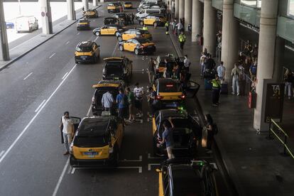 Taxistas recogen a clientes en el aeropuerto de El Prat de Barcelona, este jueves.