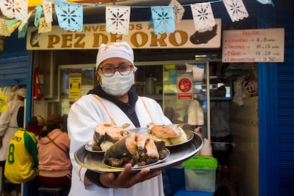 Una empleada del restaurante El Pez de Oro muestra un plato de thimpu de trucha y carachi. La especie introducida ahora se mezcla no solo en el lago, sino en la sopa con la nativa. Pincha en la imagen para ver la fotogalería completa.