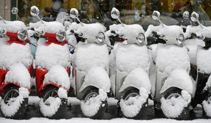 Vespas cubiertas de nieve en una calle en Zúrich (Suiza).