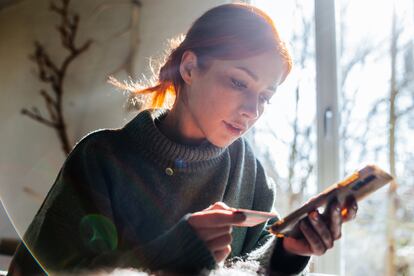 Woman shopping online with laptop and credit card on hand.