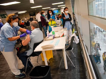 Sanitarios vacunan este viernes con dosis de AstraZeneca en el WiZink Center de Madrid.