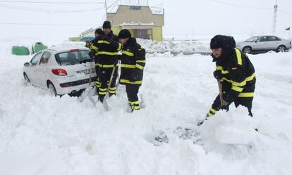 Efectivos de la UME proceden a retirar la nieve de un coche en la autovía Mudejar en los límites de Castellón y Teruel.