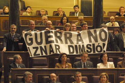 Los diputados de Izquierda Unida despliegan una pancarta contraria a la guerra contra Irak y pidiendo la dimisión de Aznar, en sus escaños, durante el pleno del Congreso en el que el presidente José María Aznar compareció, para explicar la postura del Gobierno ante la inminente guerra contra Irak, cuarta comparecencia de Aznar para informar sobre la crisis iraquí.