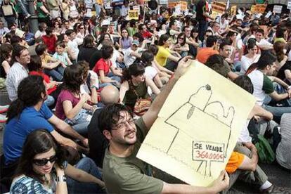 Un joven muestra un cartel sobre el alto precio de los pisos en la concentración de Madrid.