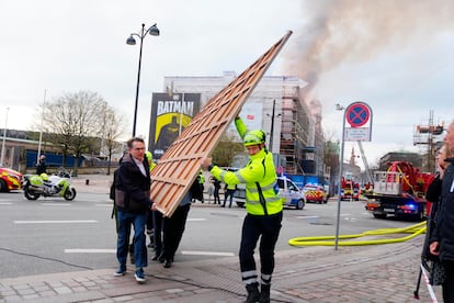 Varias personas retirar una de las obras de artes del interior del edificio incendiado en el centro de Copenhague, este martes.