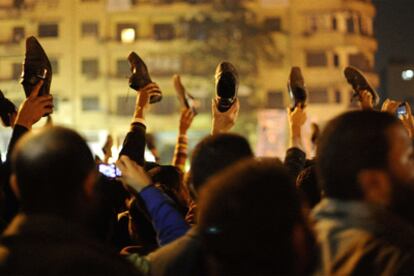 Manifestantes contrarios al régimen agitan sus zapatos tras el discurso televisado de Hosni Mubarak, en la plaza de la Liberación de El Cairo.