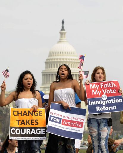 Tres manifestantes piden frente al Capitolio una reforma en las leyes de inmigración, otra de las asignaturas pendientes de la administración Obama.