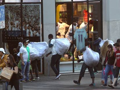 Unos manteros recogen su mercancía en el centro de Madrid.