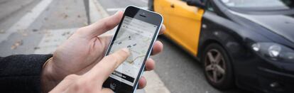 Un usuario prueba la aplicación Uber en la avenida Diagonal de Barcelona.