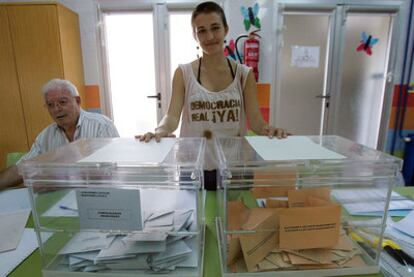 Haize Campillo, presidenta de mesa del colegio electoral Reyes Católicos, en Sant Vicent del Raspeig, luce una camiseta del Movimiento 15-M con la inscripción Democracia Real Ya.