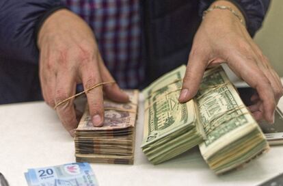 Dólares y pesos mexicanos en una casa de cambio en Texas.