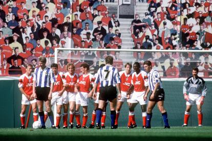 El mural en Highbury, durante un partido ante el Sheffield. Campbell, de blanco y rojo, primer jugador del Arsenal por la derecha. / GETTY