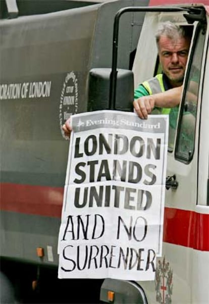 Un empleado municipal londinense sostiene un cartel que dice: "Londres permanece unido y no se rinde".