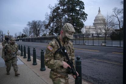Miembros de la Guardia Nacional caminan por el perímetro vallado que rodea el Capitolio de los Estados Unidos en la madrugada del 10 de febrero de 2021 en Washington, DC. Casa