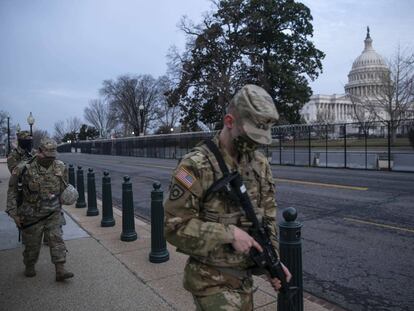 Miembros de la Guardia Nacional caminan por el perímetro vallado que rodea el Capitolio de los Estados Unidos en la madrugada del 10 de febrero de 2021 en Washington, DC. Casa