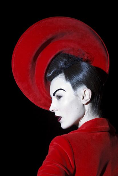 Una modelo luce la colección de Maya Hansen con chaqueta y tocado rojos.