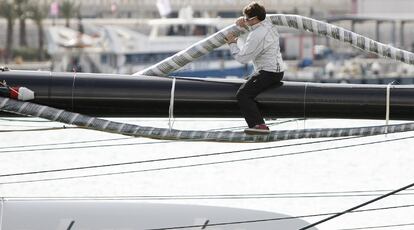 Un miembro de la tripulación del Alingui trabaja sobre el catamarán para dejar lista la embarcación.