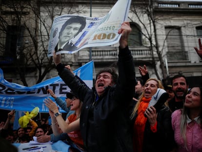 Javier Milei sostiene una gigantesca réplica de un billete de 100 dólares con su cara, durante un acto de campaña en Buenos Aires, en septiembre de 2023.