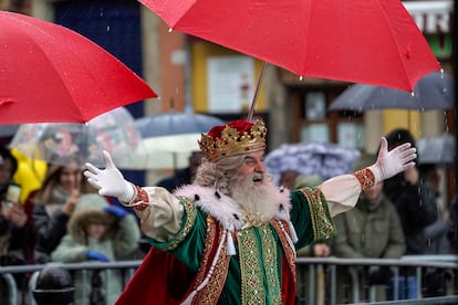 El rey Melchor se protege de la lluvia, la mañana de este viernes en Gijón, Asturias.