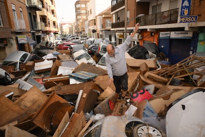 Un hombre camina por una calle cubierta de escombros en el municipio valenciano.
