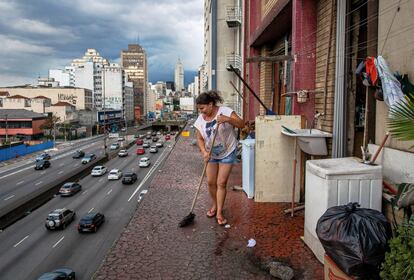 Tania Regina regenta una tienda de comestibles en el edificio. En la imagen, barre la parte posterior del establecimiento, que también hace las veces de habitación. Lleva ya cinco años viviendo en el Prestes Maia junto a su hija.