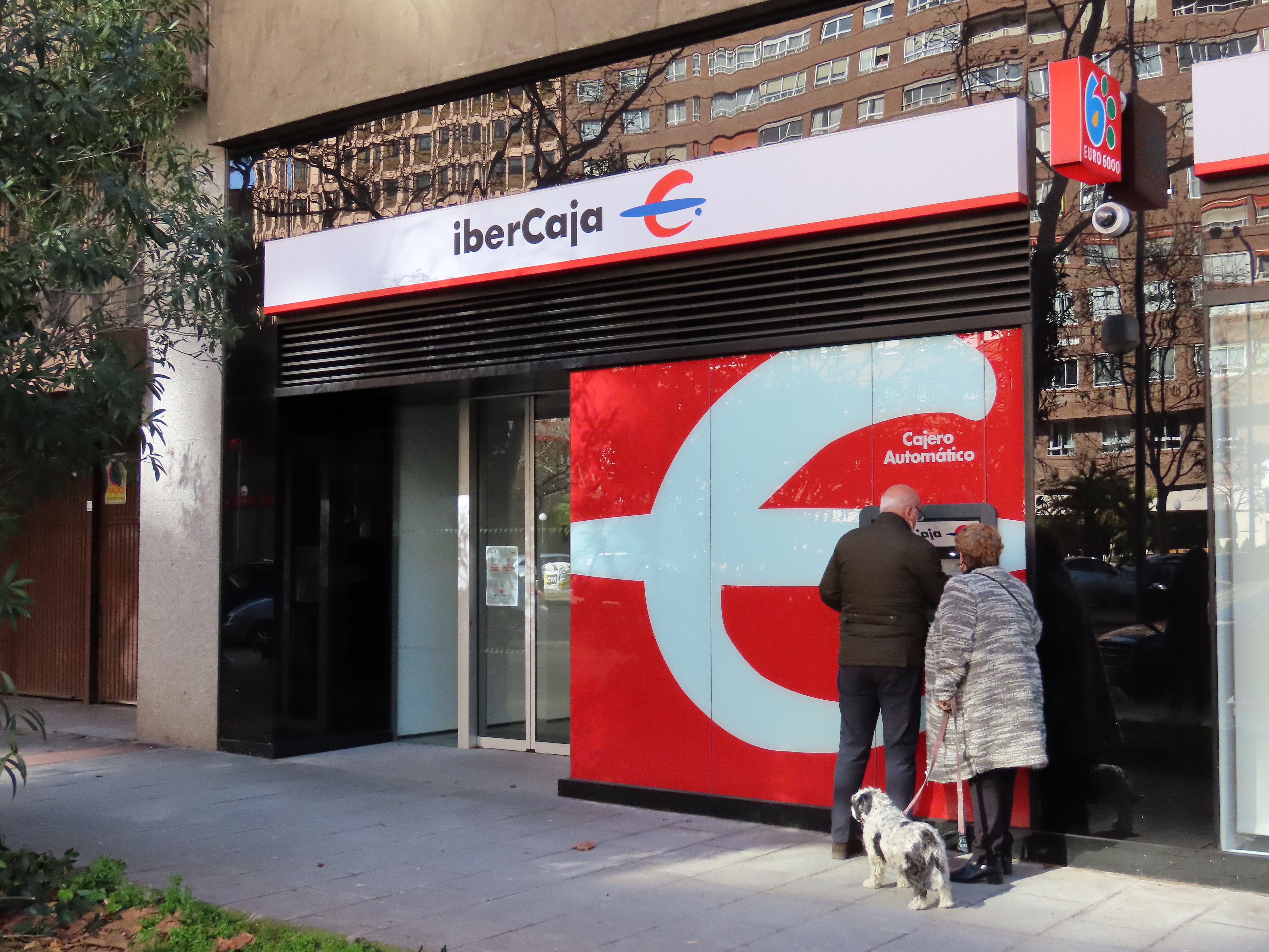 Clientes operando en un cajero automático.