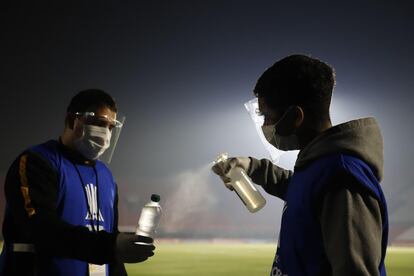 Recogepelotas desinfectan una botella de agua como prevención para evitar el contagio con el coronavirus, en un partido del grupo B de la Copa Libertadores entre Guaraní y Tigre en el estadio Defensores del Chaco en Asunción (Paraguay).