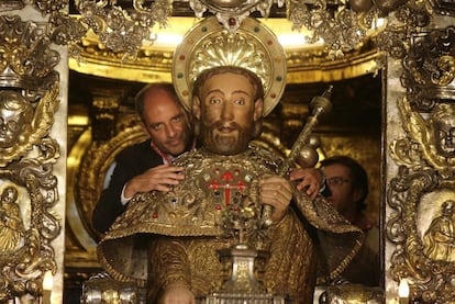 Francisco Camps abraza la estatua del apóstol Santiago. Al fondo, Núñez Feijóo.