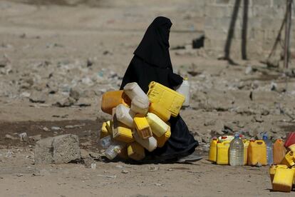 Una mujer cargada con bidones se dirige a llenarlos en un grifo de beneficiencia en Saná, la capital de Yemen.