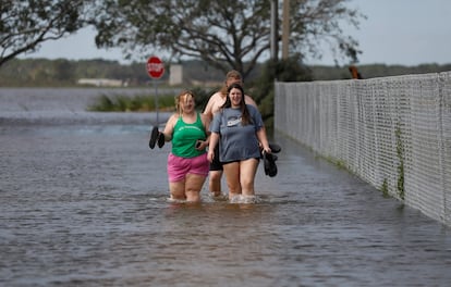 Personas por una calle inundada tras la llegada a tierra del huracán Milton, este jueves en San Petersburgo, Florida. 