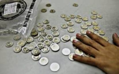 Una empleada bancaria cuenta monedas en un puesto de la estación de trenes de Retiro, en Buenos Aires (Argentina). EFE/Archivo