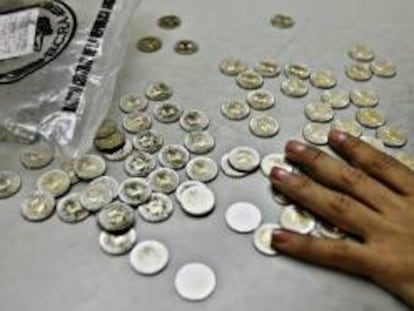 Una empleada bancaria cuenta monedas en un puesto de la estación de trenes de Retiro, en Buenos Aires (Argentina). EFE/Archivo