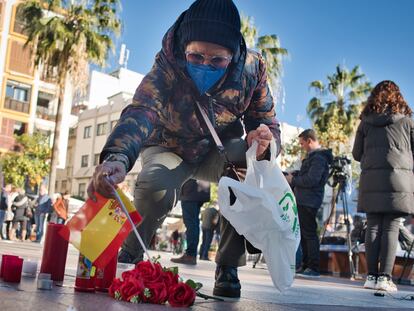 Una mujer coloca una bandera en el lugar donde fue asesinado el sacristán Diego Valencia, en Algeciras (Cádiz).
