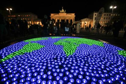 Un grupo de velas que forman la Tierra frente a la Puerta de Brandeburgo de Berlín (Alemania).