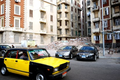 Un taxi alejandrino circula por delante de un edificio en ruinas en la calle Omar Lotfy del centro de la ciudad, el 4 de mayo de 2025.