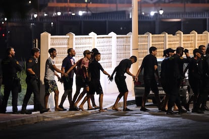 Un grupo de agentes de la Guardia Civil escolta a un grupo de inmigrantes que logró entrar en Ceuta, la madrugada de este lunes.