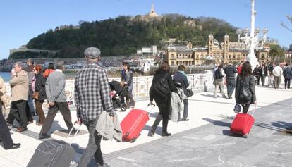 Varios turistas, en el paseo de La Concha en San Sebastián.