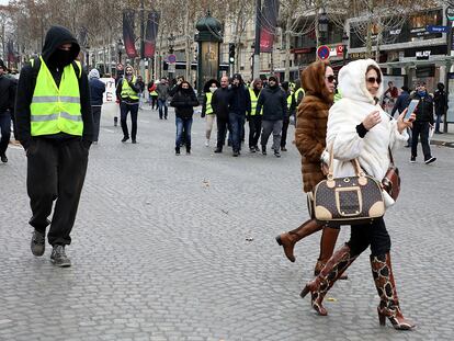 Dos mujeres pasean por los Campos Elíseos en medio de las protestas.