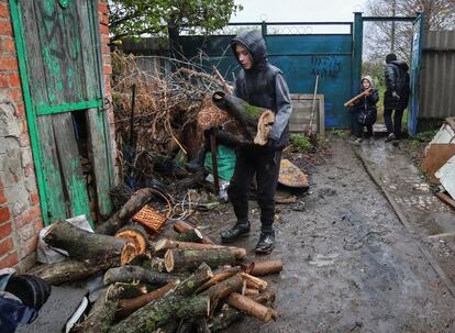 Local residents carry firewood to heat their houses in Derhachi, Kharkiv region.