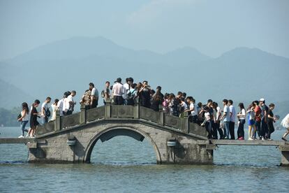 Visitantes pasean por el puente en West Lake durante la Golden Week en Hangzhou, provincia de Zhejiang (China). 