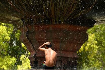 Un hombre se refresca en una fuente en Nueva Delhi.