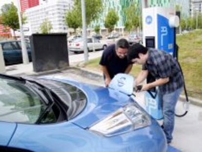 Un operario coloca junto al cliente el enchufe en el coche. EFE/Archivo