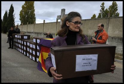 María Caridad Delgado traslada una caja con restos identificados de un familiar. El resto de huesos encontrados en una fosa común serán colocados en un nicho comunitario, a expensas de que haya dinero para hacer pruebas de ADN y poder identificarlos, el 2 de noviembre de 2013, en Aranda de Duero (Burgos).